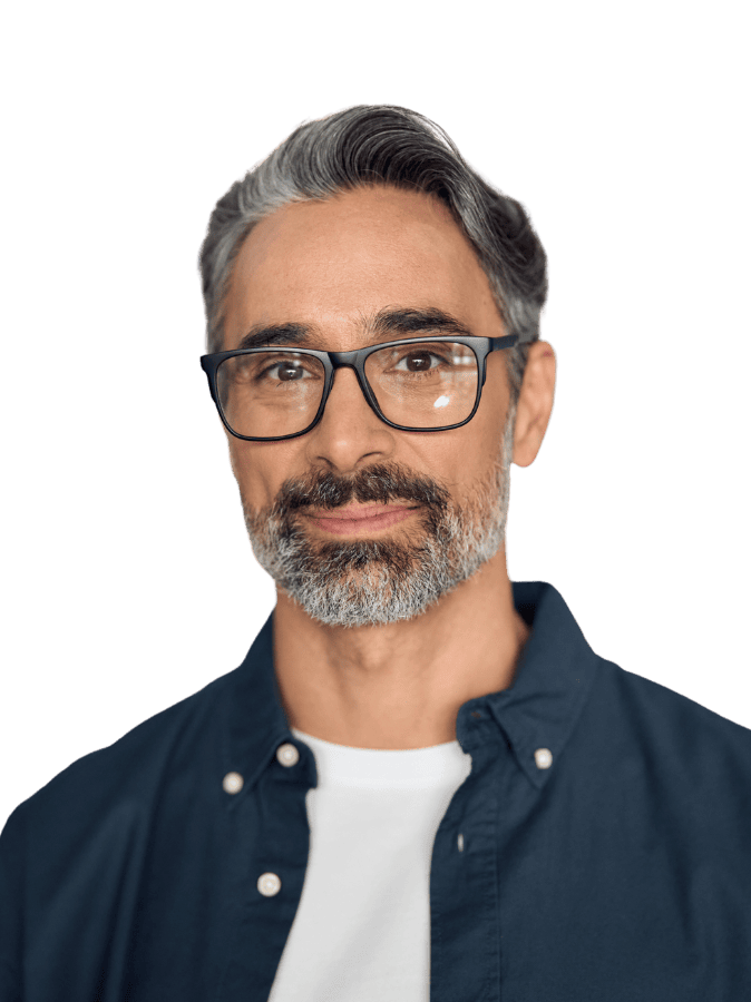 A person with glasses and facial hair wearing a blue shirt, poses against a plain black background, looking directly at the camera.