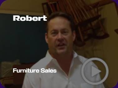 A person in a white shirt stands indoors, with wooden furniture in the background. Text reads "Robert" and "Furniture Sales."