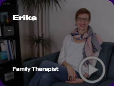 A person is sitting on a couch, smiling. The text reads "Erika, Family Therapist." A small plant is visible in the background.
